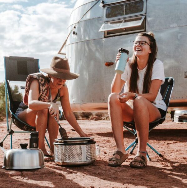 Groep mensen samen aan het barbecueën bij hun camper