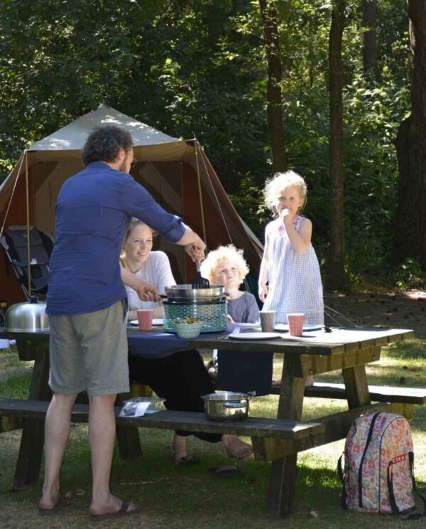 Gezin bij picknicktafel op camping met COBB