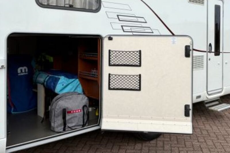 Witte camper met COBB in tas in garage