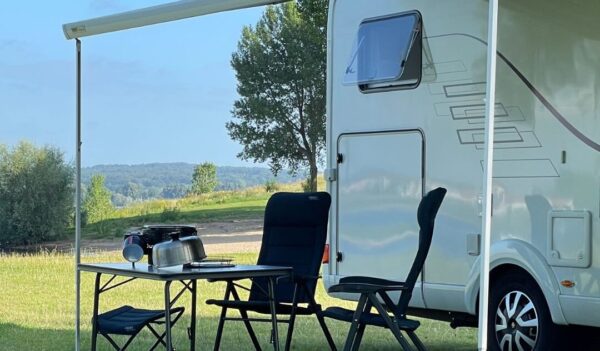 Witte camper met COBB barbecue op tafel