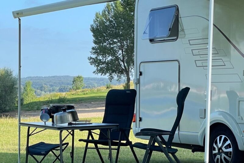 Witte camper met COBB barbecue op tafel